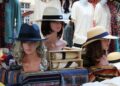 Mannequins wearing hats at an outdoor market.
